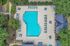 Inviting aerial view of a luxury swimming pool surrounded by elegant lounge chairs and lush greenery, creating a serene oasis for relaxation.