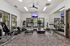 Modern apartment gym with state-of-the-art exercise equipment, natural lighting, and a large mirror wall.