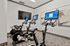 Modern fitness room showcasing advanced stationary bikes with interactive screens and stylish art d&eacute;cor.
