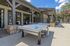 Inviting outdoor recreation area featuring a professional ping pong table under a stylish wooden pergola, perfect for leisure and entertainment.