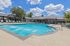 Luxurious community pool with crystal clear water, surrounded by sun loungers and scenic views, ideal for relaxation and leisure.