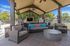 Chic outdoor lounge area featuring comfortable wicker seating with vibrant blue cushions under a stylish pergola, perfect for relaxing and socializing.