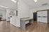 Modern laundry room featuring sleek washers and dryers, ample folding space, and natural light through large windows.