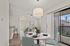 Bright, open-concept living and dining area with modern decor, stylish fixtures, and floor-to-ceiling windows offering abundant natural light and balcony access.