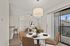Bright, modern apartment interior featuring a cozy living area, a sophisticated dining table setup, and sliding glass doors leading to a balcony.