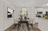 Elegant dining area with sleek modern chairs, a stylish dining table, and contemporary artwork. Adjacent open kitchen with white cabinetry and stainless steel appliances for a cohesive look.