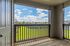 Charming balcony view showcasing lush green lawns and a vibrant, sunny sky.