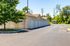 Charming residential garages with pristine white doors, surrounded by lush greenery and blue skies, offering ample parking space.