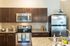 Chic modern kitchen with stainless steel appliances, elegant granite countertops, and rich wooden cabinetry.