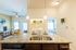 Bright open-concept apartment kitchen leading into a cozy living room, featuring granite countertops, modern appliances, and elegant decor.