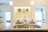 Chic kitchen with granite countertops and modern double sink, leading to a cozy laundry area, complemented by bright and airy bedrooms ideal for comfortable living.