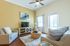 Inviting living room with elegant neutral tones, featuring a cozy seating area, stylish wicker coffee table, and natural light streaming through the windows.