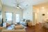 Bright and welcoming living room featuring cozy seating, elegant decor, and natural light pouring through large windows.