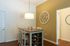 Charming dining area with elegant pendant lighting, stylish wall clock, and cozy seating, perfect for intimate gatherings.