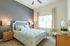 Bright and inviting bedroom showcasing elegant decor, natural light, and a stylish headboard for a serene retreat.