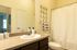 Inviting bathroom featuring modern fixtures, elegant vanity, and artful wall decor with ample natural light.