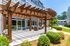 Charming outdoor patio with stylish wooden pergola and cozy seating, ideal for relaxation and entertaining amidst lush greenery.