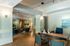 Elegant apartment lobby featuring warm wooden flooring, stylish seating area, and modern lighting, creating a welcoming atmosphere.
