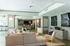 Elegant communal living area with plush seating, modern decor, and multiple wall-mounted TVs, perfect for relaxation and social gatherings.