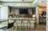 Modern lounge area with a colorful mosaic backsplash, sleek bar stools, and inviting decor, perfect for relaxation and socializing.