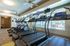 Modern fitness center with a row of state-of-the-art treadmills and large windows letting in plenty of natural light.