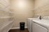 Modern laundry room with sleek washer and dryer, ample shelving, and elegant lighting, offering convenience and style.