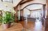 Elegant living space with rich wood accents, arched entryway, and large windows flooding the room with natural light.