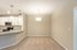 Modern open-plan kitchen and dining area with sleek white cabinetry, stainless steel appliances, and contemporary pendant lighting.