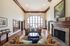 Luxurious, high-ceilinged living room with elegant couches, stunning arched windows, and a classic fireplace, perfect for sophisticated gatherings.
