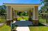 Charming gazebo with elegant columns and stone accents in a lush, green outdoor setting, perfect for relaxation.