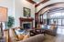 Elegant living room featuring plush sofas, a cozy fireplace, and tall arched windows creating a bright, welcoming space.