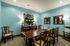 Cozy communal dining space with elegant wooden furniture, vibrant blue walls, and ambient lighting for a warm atmosphere.