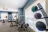 Inviting fitness center with modern equipment, including treadmills, exercise bikes, and strength machines beneath bright natural lighting.