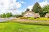 Inviting entry to Summer Lake Luxury Apartment Homes with vibrant landscaping and a welcoming sign under a bright, blue sky.