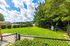 Beautiful communal outdoor space with lush green lawn, cozy seating, and scenic water views, perfect for relaxation and enjoyment.