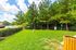 Lush green fenced outdoor area with vibrant trees, ideal for relaxation and recreation.