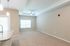 Bright and inviting living space with soft carpeting and elegant ceiling fan, perfect for relaxation and entertaining.