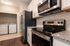Modern kitchen with stainless steel appliances, granite countertops, and an adjacent laundry area with washer and dryer.