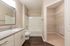 Elegant bathroom with granite countertops, sleek fixtures, and an adjoining spacious walk-in closet.