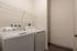 Sleek laundry room featuring modern washer and dryer with ample shelving and storage space.