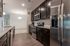 Modern kitchen featuring sleek stainless steel appliances, elegant dark cabinetry, and a chic open-concept design.