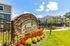 Inviting entrance to Summer Lake Luxury Apartment Homes, featuring vibrant landscaping and modern architecture under a clear blue sky.