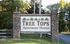 Inviting entrance sign for Tree Tops Apartment Homes, surrounded by lush greenery and rustic stone pillars.