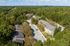 Scenic aerial view of modern apartment buildings nestled in lush greenery, offering tranquil living surrounded by nature.