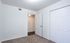 Inviting bedroom with plush carpet, ample closet space, and modern white walls, offering a bright and cozy atmosphere.