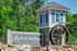 Charming entrance sign for Rock Island Ridges at Riverchase, featuring a rustic water wheel and lush greenery.