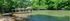Scenic lakeside view featuring a charming wooden gazebo and lush greenery, ideal for relaxation and nature lovers.