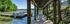 Picturesque lakeside view with a charming wooden walkway, surrounded by lush green trees and serene water, ideal for relaxation and outdoor enjoyment.