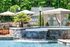 Luxurious outdoor pool area with cascading waterfall, surrounded by lush greenery, chic patio furniture, and elegant cabanas.
