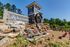 Charming entrance to Rock Island Ridges at Riverchase featuring a rustic water wheel and elegant stonework surrounded by lush greenery.